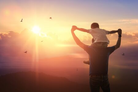 Son riding back father with outdoors on background sunset. Father holidayの写真素材