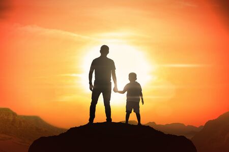 Father and son holding hand in hand at the sunset time.の写真素材