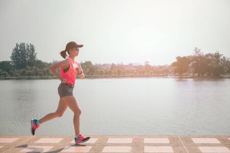 Portrait of Sporty female jogger morning exercise in the park.の写真素材