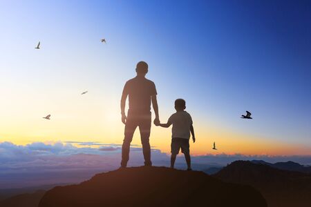 Father and son holding hand in hand at the sunrise time.の写真素材