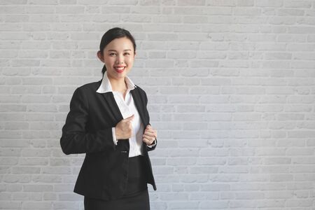 Asian female businesss smiling and wearing suit on wall background.の写真素材