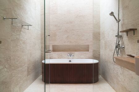 Brown bathroom interior with a brown mosaic, a white floor, an oval tub.の写真素材