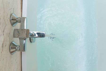 Luxury  bath tub and faucet with water.の写真素材