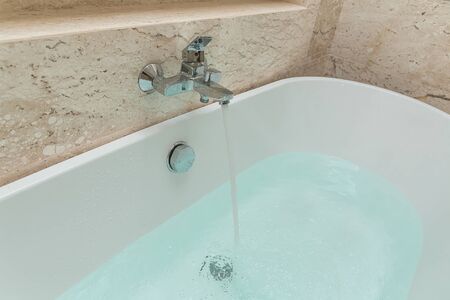 Luxury  bath tub and faucet with water.の写真素材