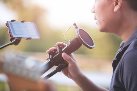 Close-up Singer holding a microphone stand and performing.の写真素材