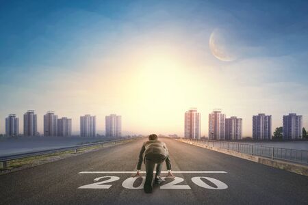 Asian business person ready to run new year 2020 toward the city. Business conceptの写真素材