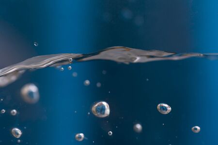 Water splash with bubbles. Splash of water on Blue background.の写真素材