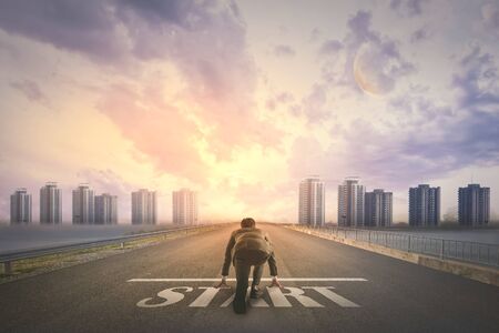 Asian business person ready to run START toward the city. Business conceptの写真素材