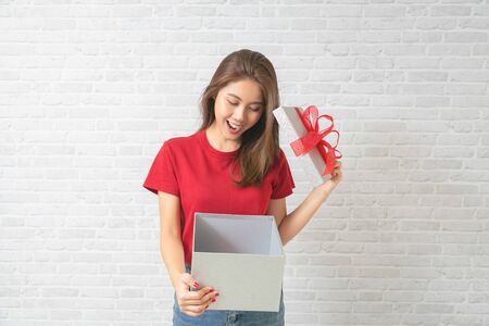 Young beautiful woman happy smiling and holding gift boxes presents.の写真素材