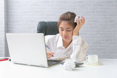 Serious asian business woman working on laptop at office.の写真素材