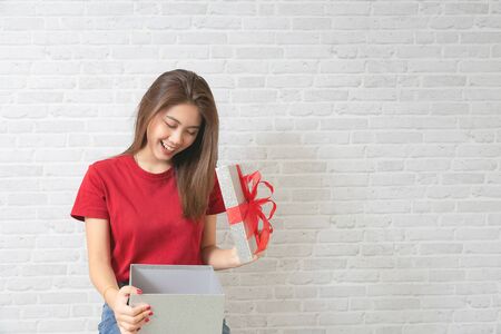 Young beautiful woman happy smiling and holding gift boxes presents.の写真素材