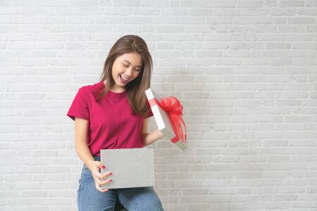 Young beautiful woman happy smiling and holding gift boxes presents.の写真素材
