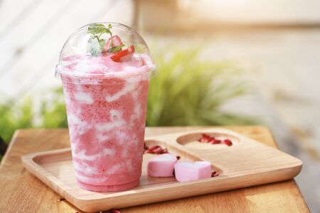 Healthy strawberry smoothie in a jar mug with candy in rustic wood.の写真素材