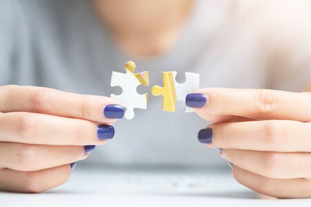 Businesswoman hand connecting jigsaw puzzle at outdoor. Business success and strategy conceptの写真素材