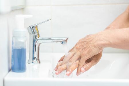 Man hands use soap and washing her hands under the faucet. Hygiene conceptの写真素材