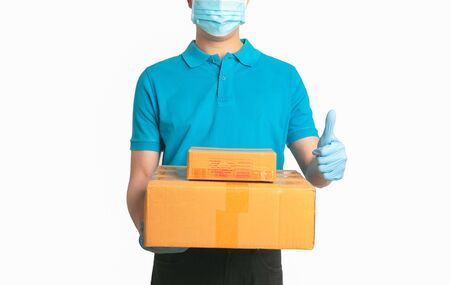 Delivery man employee in blue shirt uniform face mask gloves hold empty cardboard box isolated white background.の写真素材
