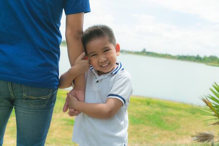 Little boy hug in hand his dad outdoor in the park.の写真素材