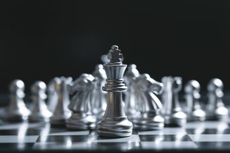 King of battle chess game stand on chessboard with black isolated background. Business leader concept.の写真素材