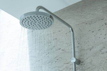 Fresh shower with water drops splashing. Faucet in modern bathroom.の写真素材