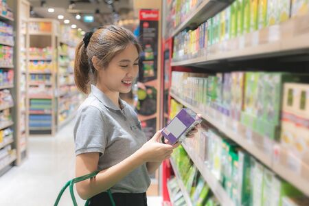 Beautiful young asian woman shopping in a grocery supermarket.の写真素材