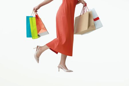 Woman of half body in red pants holding multicolored shopping bags isolated white background.の写真素材