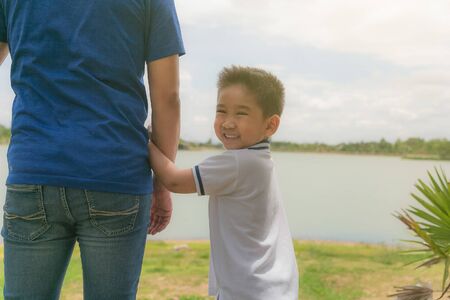Little boy hug in hand his dad outdoor in the park.の写真素材