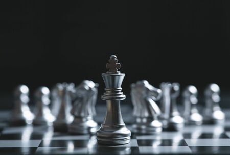 King of battle chess game stand on chessboard with black isolated background. Business leader concept.の写真素材