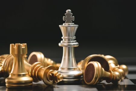 Human hand moving dark King chess piece at tableの写真素材