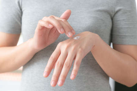 Closeup of hands applying moisturizer. Beauty woman holding care cream of skin cream.の写真素材
