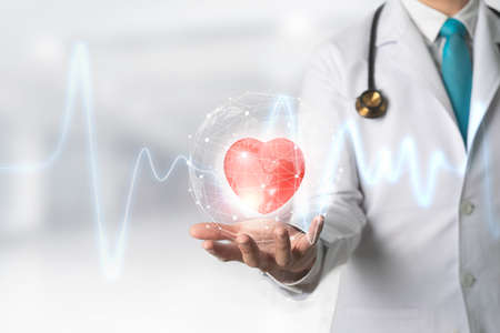 Medicine doctor holding red heart shape in hand with Technology Innovation and medicine concept.の写真素材