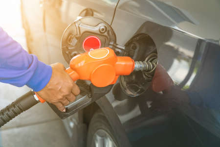 Man handle pumping gasoline fuel nozzle to refuel. facility at petrol station.の写真素材