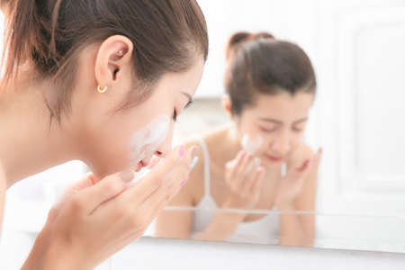 Young beauty woman washing her face in bathroom.の写真素材
