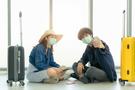 Couple love in airport using travel app on tablet.の写真素材