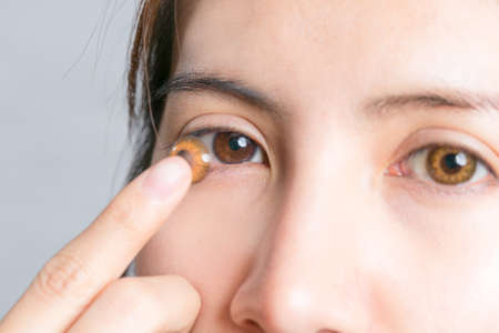 Close-up shot of young woman wearing or remove contact lens.の写真素材