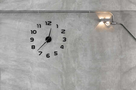 Clock in grey concrete wall.