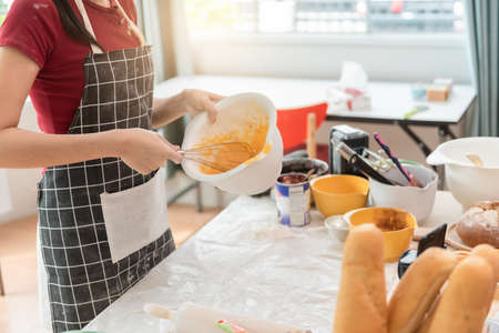 Happy woman use fresh natural products flour milk eggs kneading dough for pastries cookies by hands...