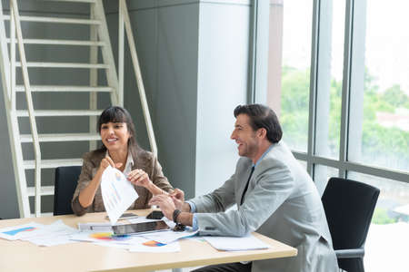 Two analysts discussing in front of laptop at office.の写真素材