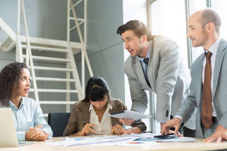 Two analysts discussing in front of laptop at office.の写真素材