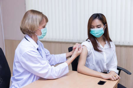 Doctor measures the pressure of the patient during a medical examination and discuss in the hospital.の写真素材