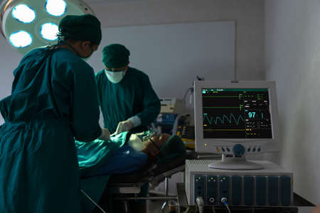 Assistant hands out instruments to surgeons during operation.の写真素材