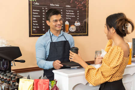 Two happy cafe managers working and happiness on laptop in their coffee shop.の写真素材