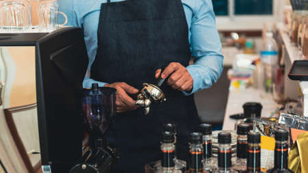 Close-up image of male barista preparing fresh coffee.
