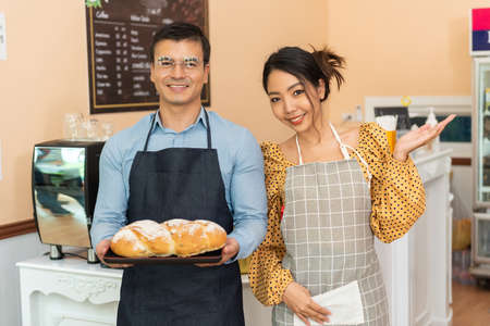 Two happy cafe managers working and happiness on laptop in their coffee shop.の写真素材