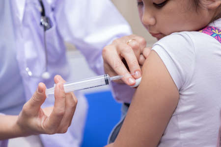 Close-up of Pediatrician doctor doing vaccination of a little girl.の写真素材