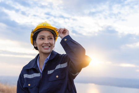 Young female engineer smiling and holding harthat looking to the future.