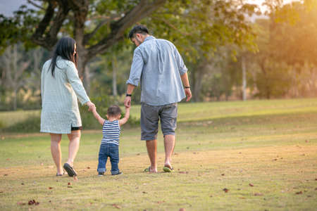 Family lovewalk in the park with happy at sunset.の写真素材