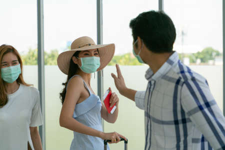Group of young Asian travelers wearing face mask greeting in the airport with a new normal lifestyle. Coronavirus covid-19 concept.の写真素材