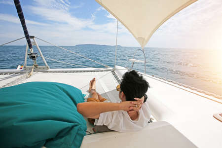 Man relaxing lie down on Sailboat Deck spending summer day outside.の写真素材