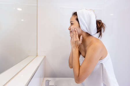 Asian Woman wash her face in the bathroom after shower.の写真素材