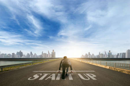 businessman person ready to run START UP toward the city. Business start-up concept.の写真素材